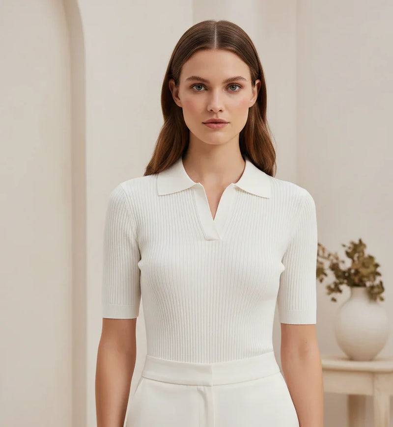 Mulher vestindo blusa branca canelada de manga curta e gola, em ambiente elegante e minimalista